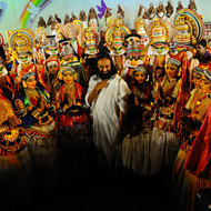 sri sri ravishankar standing amidst kathakali artists on stage